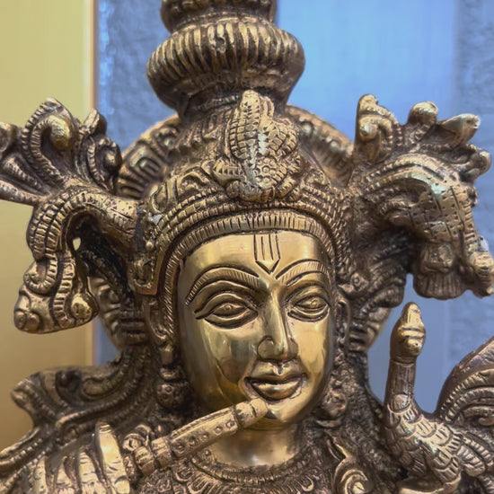 Video turning around the 24 inch brass Krishna statue, showing the bansuri flute, hand-engraved crown and jewellery, the layered lotus base and the fully finished back with its lotus-mandala halo disc.