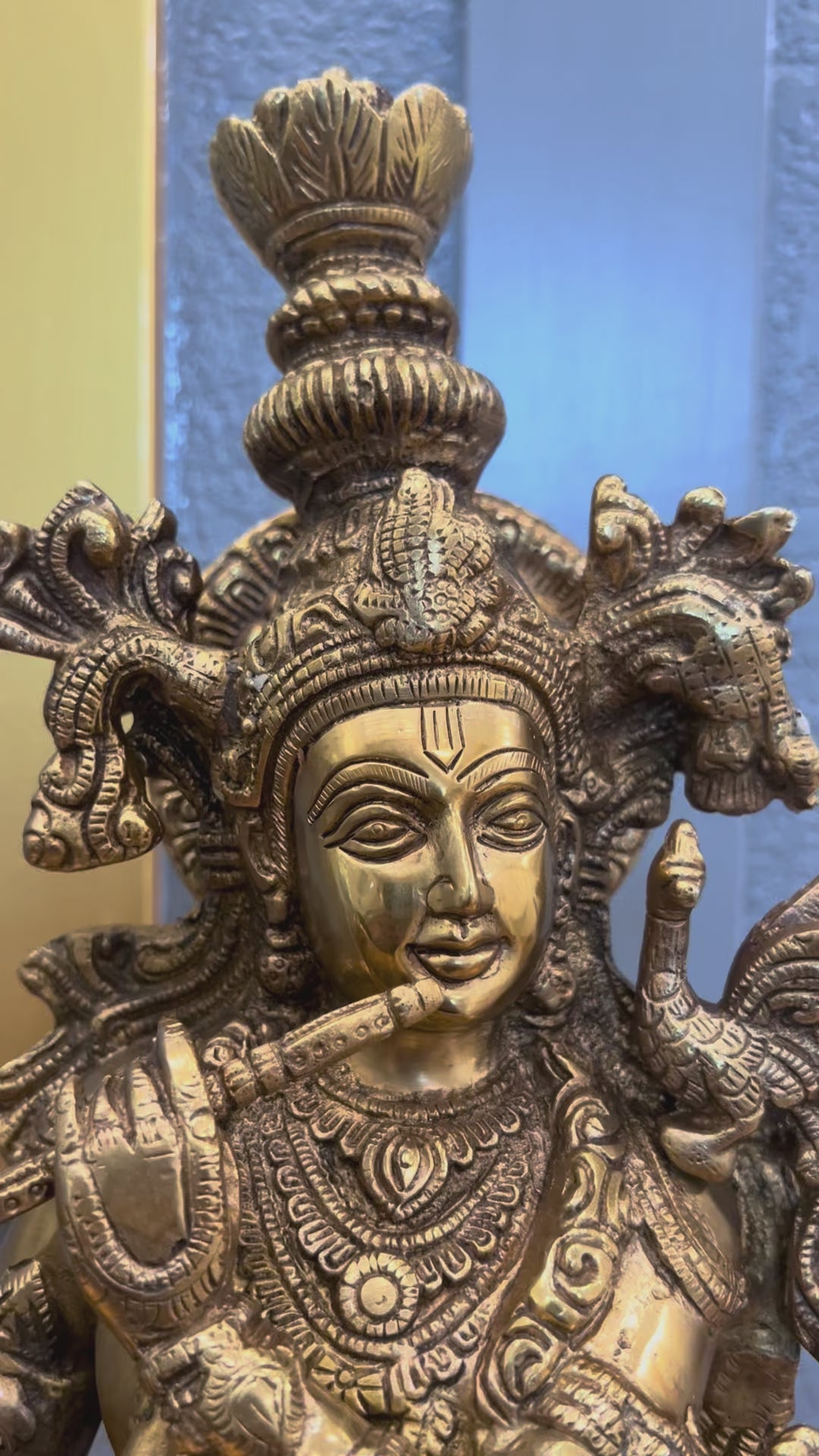 Video turning around the 24 inch brass Krishna statue, showing the bansuri flute, hand-engraved crown and jewellery, the layered lotus base and the fully finished back with its lotus-mandala halo disc.