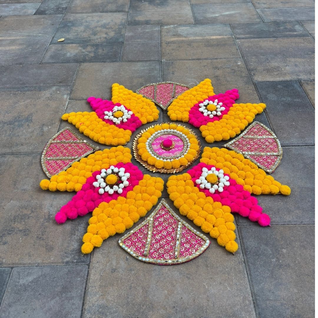 The Trishul rangoli set as a centerpiece, highlighting the floral design.