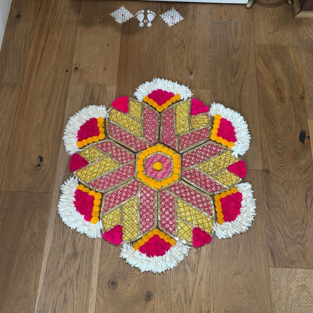Colorful hexagon motif rangoli mat on a wooden floor