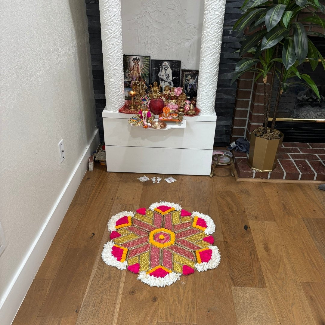 Decorative MDF rangoli on the floor in front of a white cabinet with religious items.