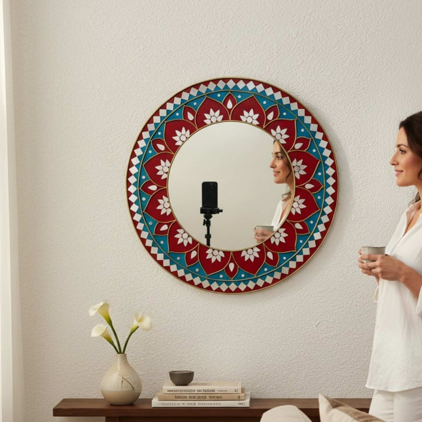 Woman standing in front of a red lippan mandala mirror
