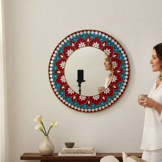 Woman standing in front of a red lippan mandala mirror
