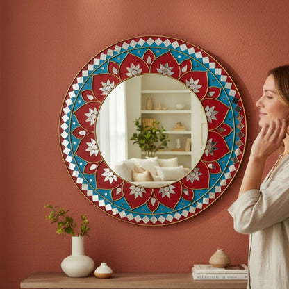 Woman standing in front of a red lippan mandala mirror by urli utsav decor