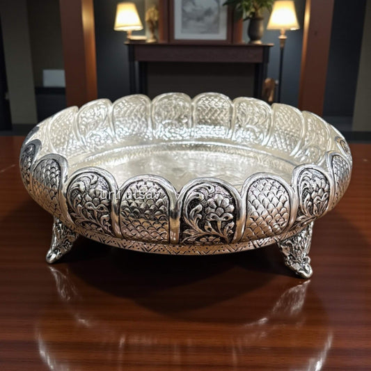 Rose Engraved Antique Silver Urli Bowl with intricate patterns on a wooden surface