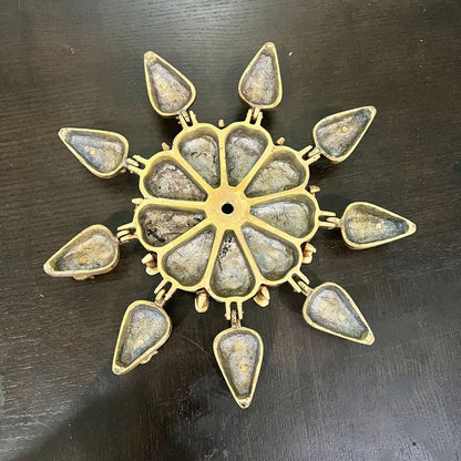 Top view of brass peacock kumkum box open in star shape, 9 teardrop compartments
