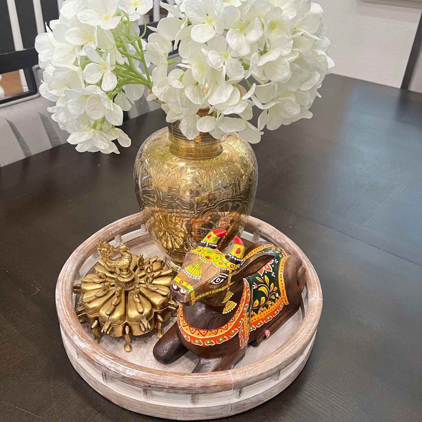 Brass Shingardani styled with wooden cow figurine and white florals on decorative tray