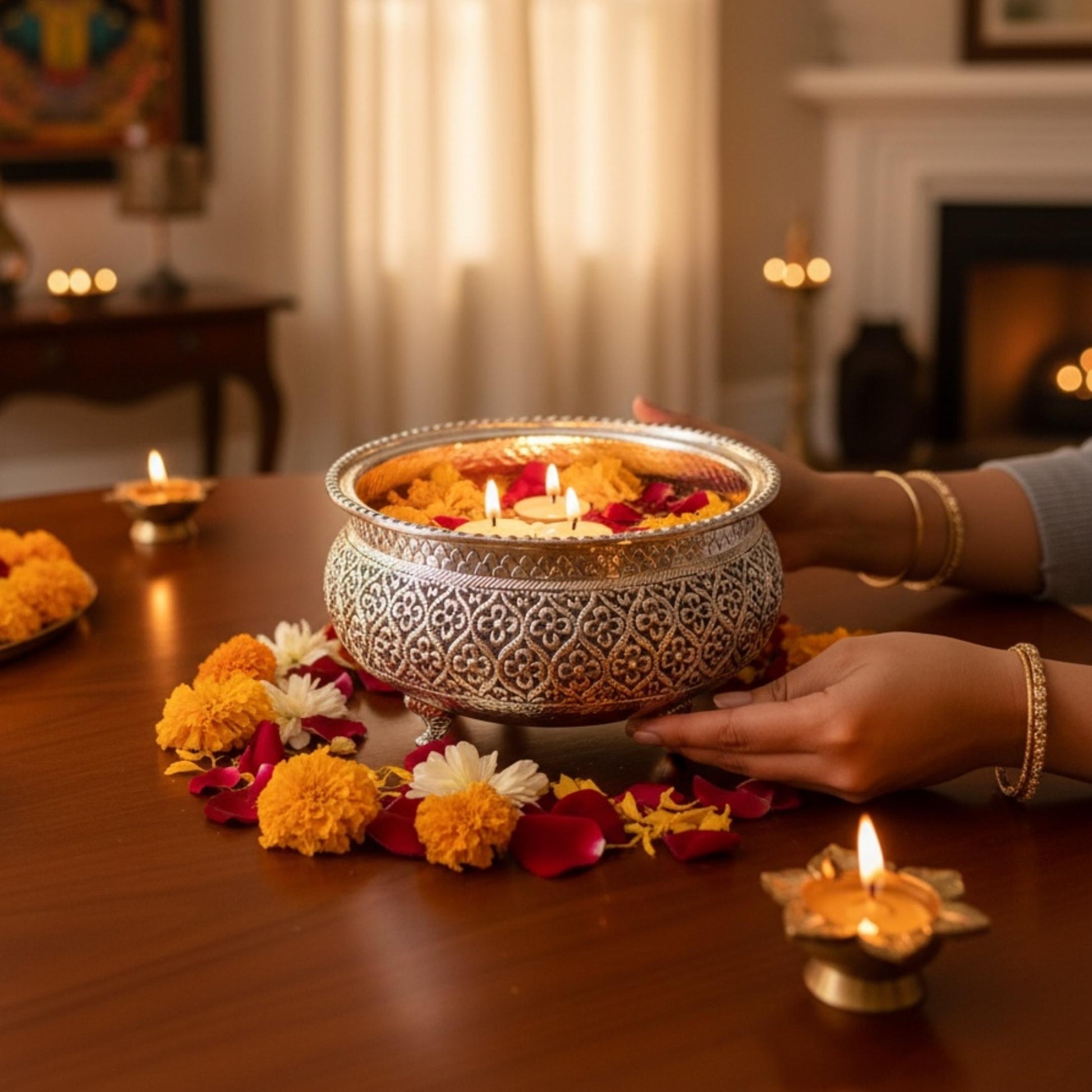 Diwali Decoration, Antique silver flower engraved urli bowl from Urli Utsav styled with candle decor next to fireplace, german silver urli bowl decor inspiration