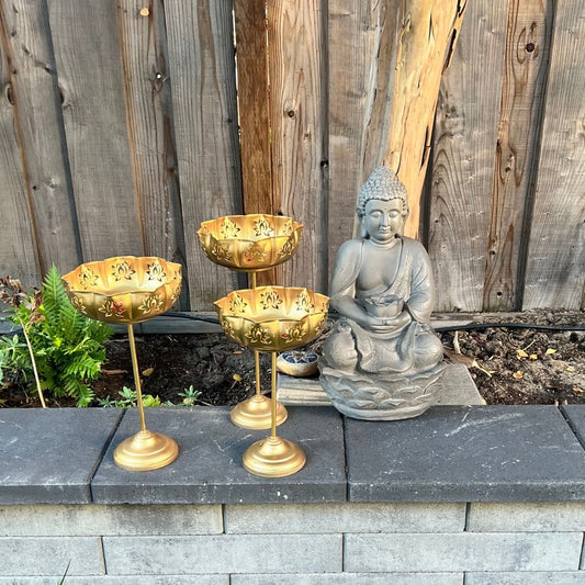 Gold Lotus Motif Urli Set of 3 by Urli Utsav Decor — standing decorative bowls shown outdoors with Buddha; Diwali & wedding centerpiece