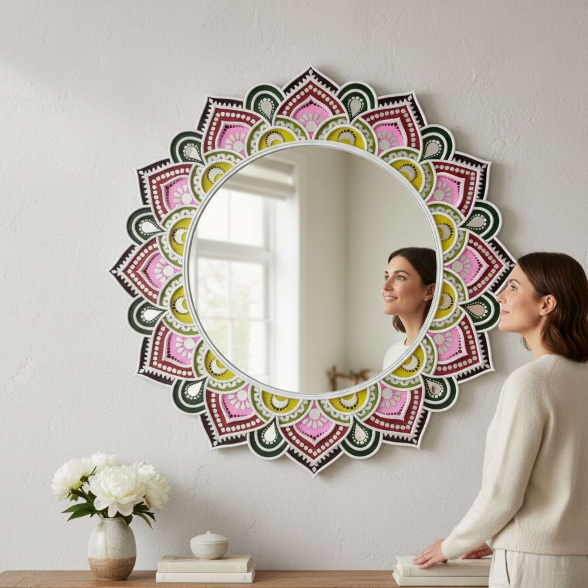 Woman looking at a urli utsav wall mirror with a colorful floral frame.