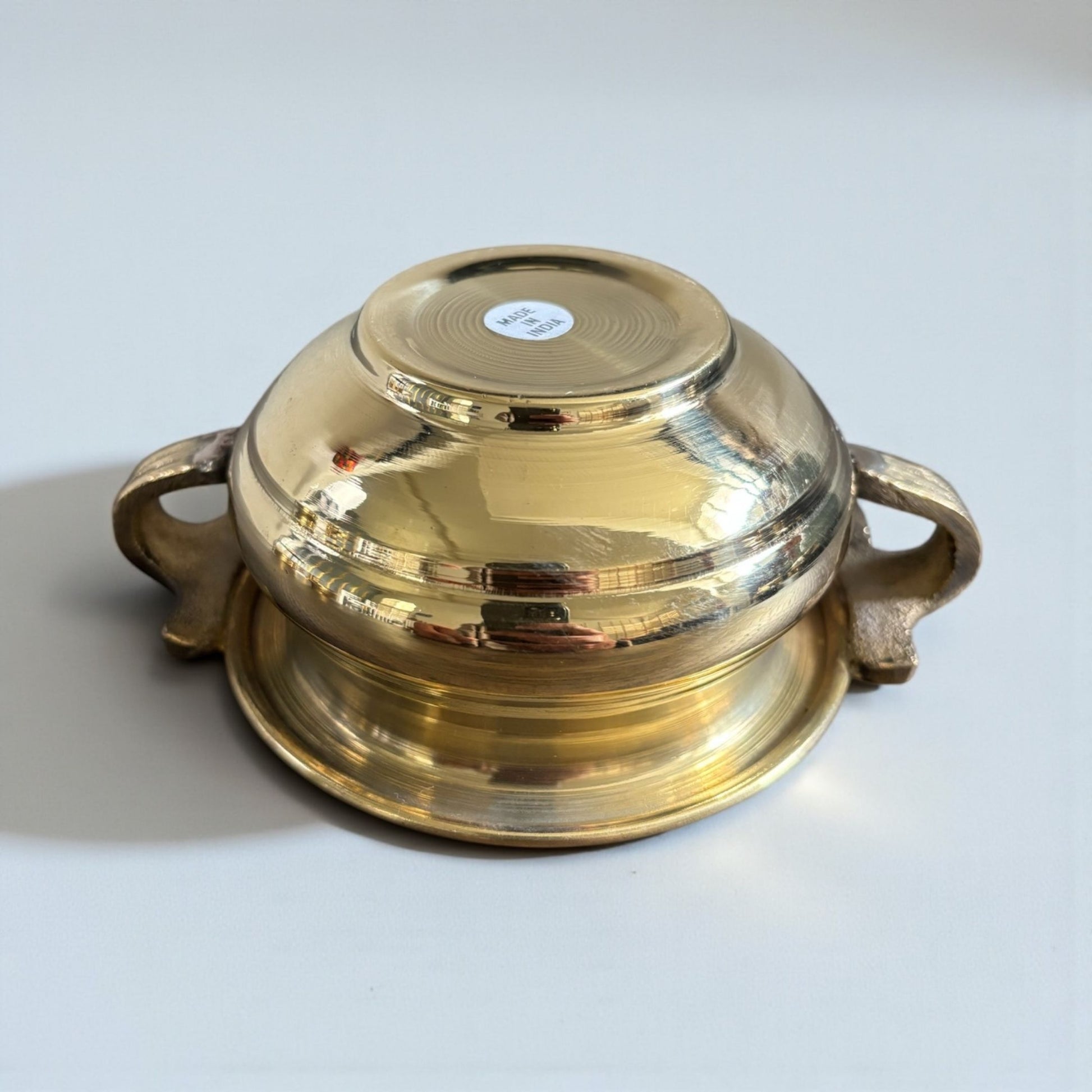 Flipped brass bowl dish on white background – Indian brass urli decorative bowl