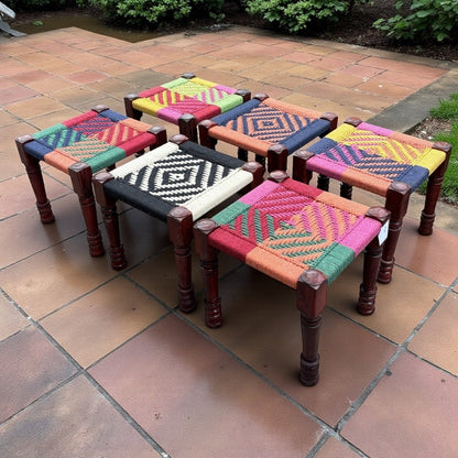 Set of colorful woven stools on a tiled patio