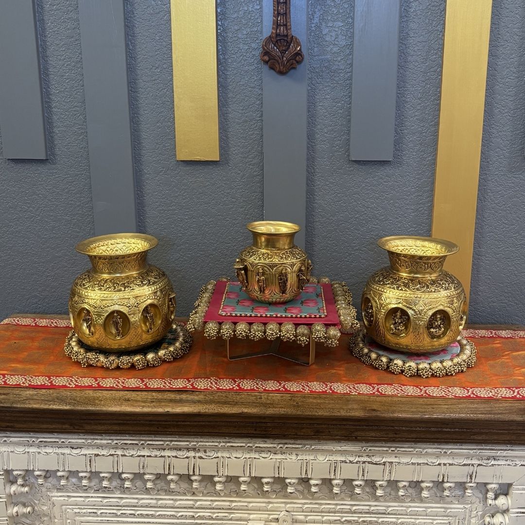 Three brass Ashtalakshmi Dashavatar kalash pooja lotas displayed on wooden console table