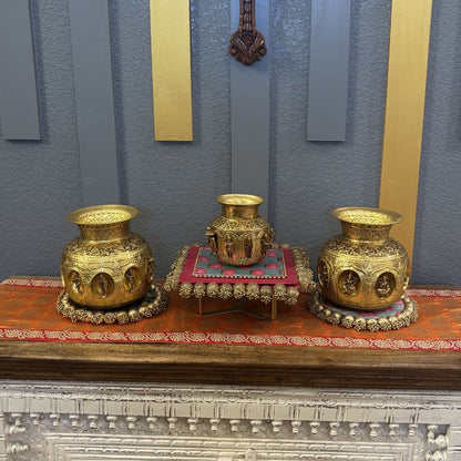 Three brass Ashtalakshmi Dashavatar kalash pooja lotas displayed on wooden console table