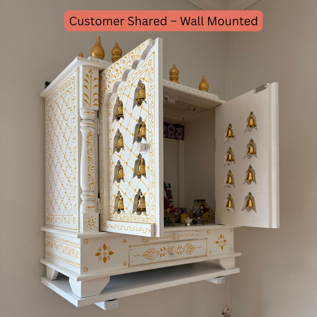Wall-mounted white and gold decorative urli utsav mandir with open doors showing interior.