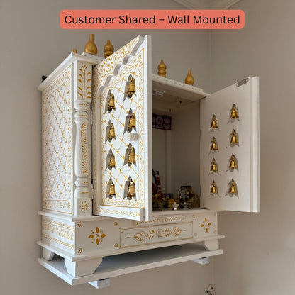 Wall-mounted white and gold decorative urli utsav mandir with open doors showing interior.
