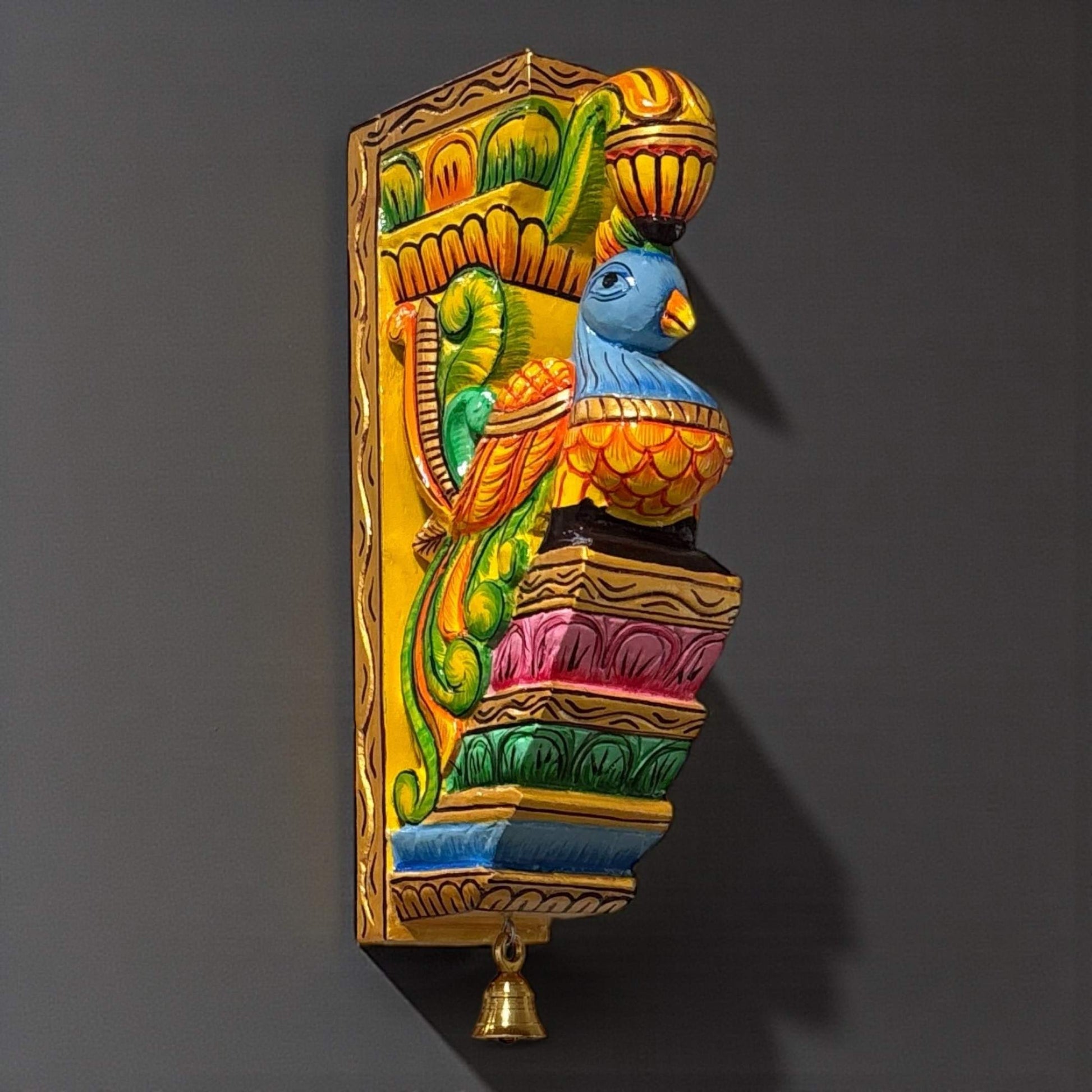 Close-up of the intricate hand-painted peacock feathers and floral motifs on a handcrafted wooden wall corbel.