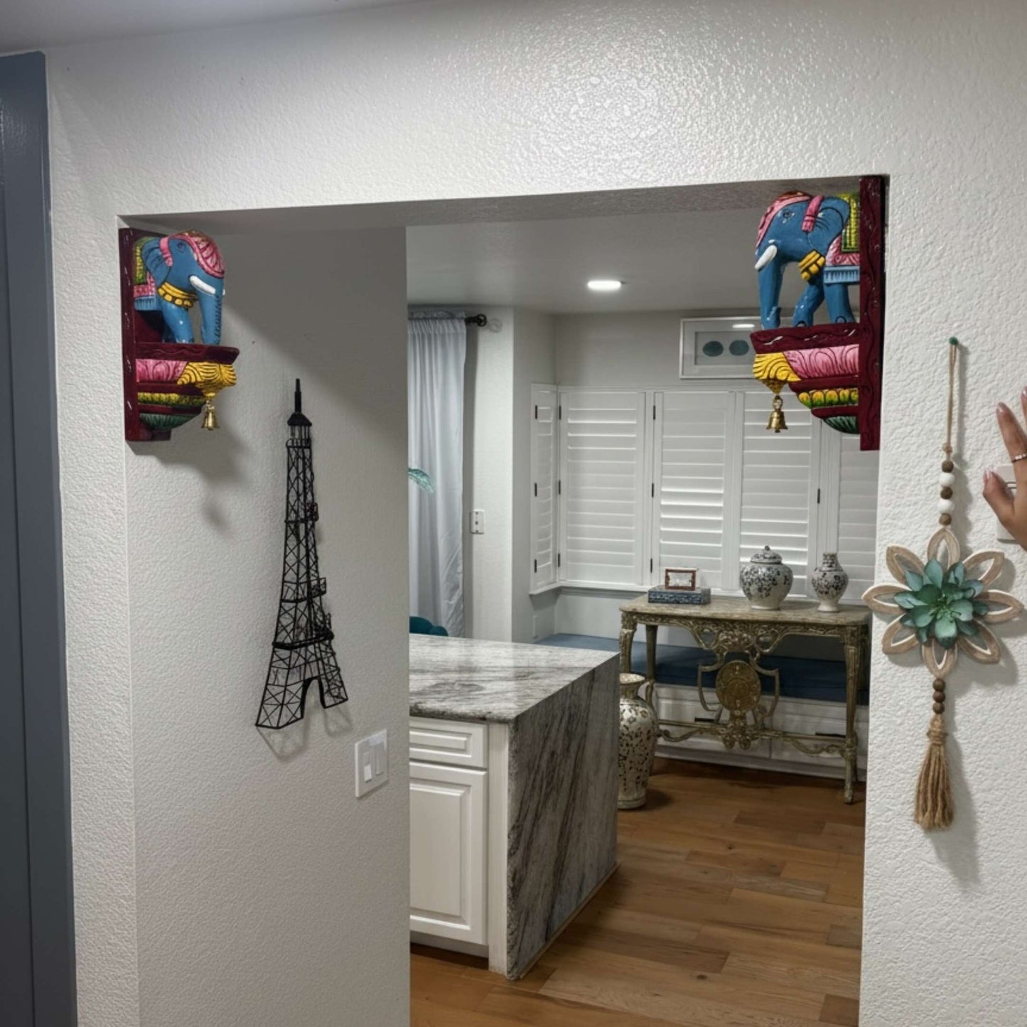 Hand-carved elephant corbel installed as a wall shelf bracket for traditional Indian pooja room decor.