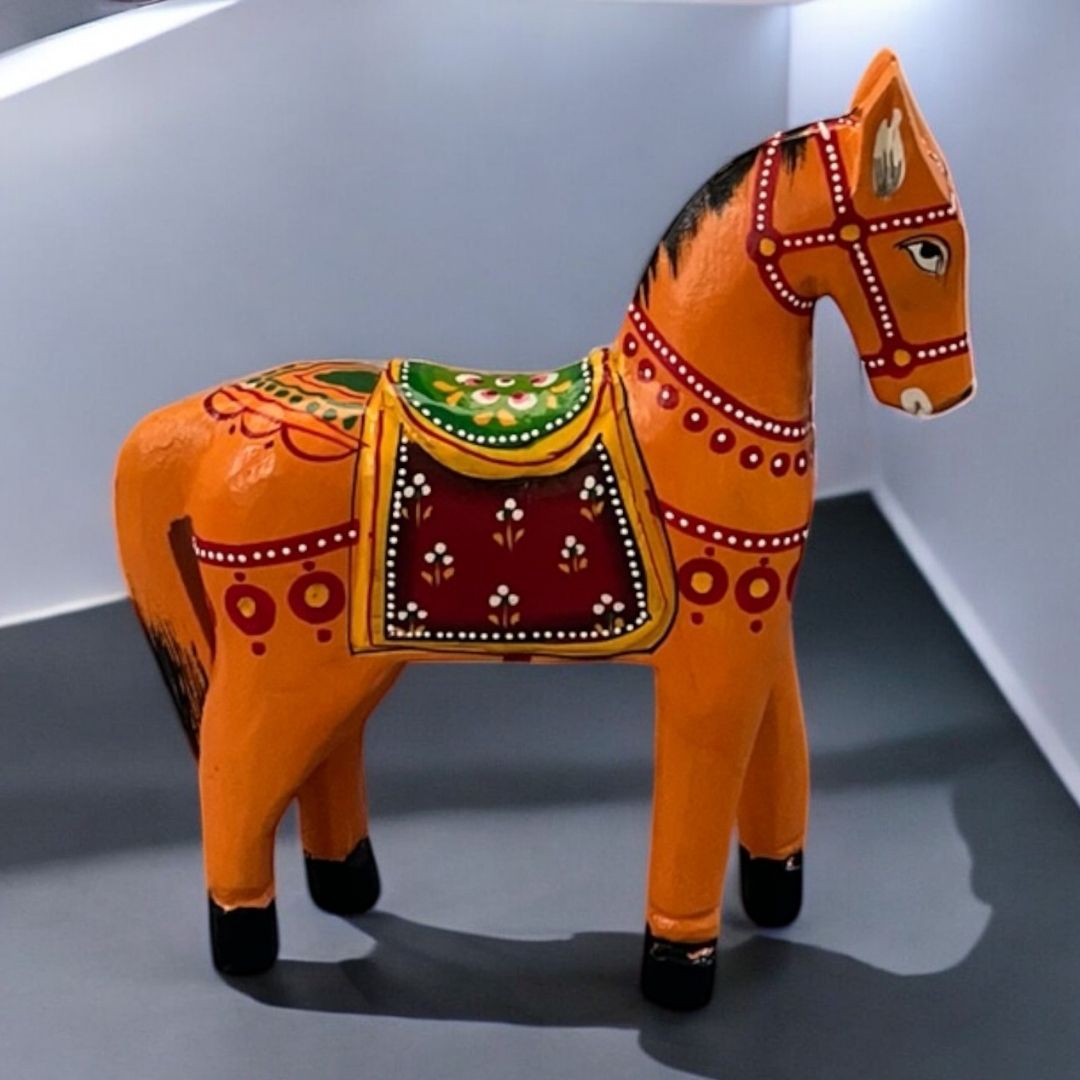Decorative orange horse figurine with colorful patterns on a gray background