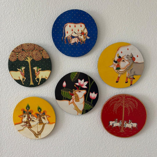 Handpainted wall plate displayed on a white wall, highlighting its vibrant colors and intricate pichwai cow patterns for home decor inspiration